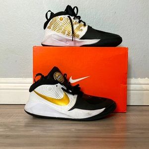 Gold, black, and white Nike Basketball shoes.